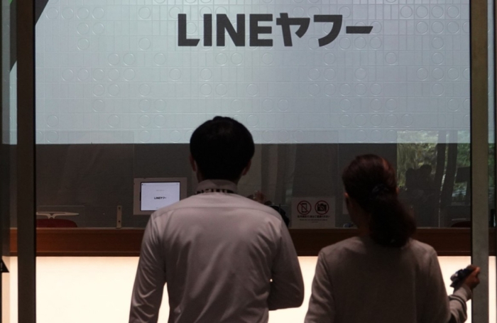 People　walk　into　the　Tokyo　Garden　Terrace　Kioi　Tower,　the　building　that　houses　LY,　the　Line　app　operator