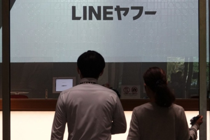 People　walk　into　the　Tokyo　Garden　Terrace　Kioi　Tower,　the　building　that　houses　LY,　the　Line　app　operator