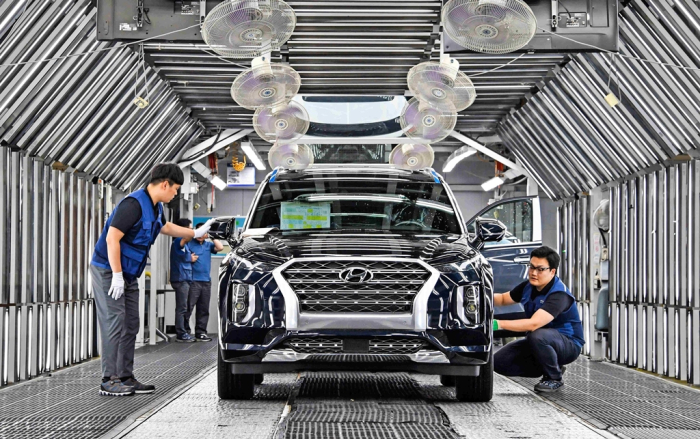 Hyundai Motor employees examine an SUV at its plant