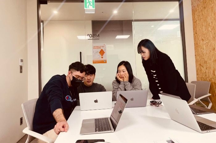 Momo　Project　developers　work　with　founder　and　CEO　Rebekah　Younmo　Kang　(center,　seated)　(Courtesy　of　Momo　Project) 