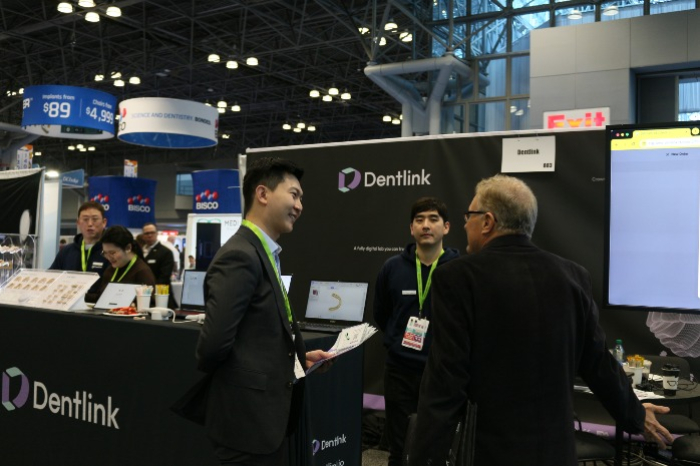 Innovaid　founder　and　CEO　Kook　Jin　Hyeok　(left)　talking　to　a　visitor　to　the　Dentlink　booth　at　a　dental　technology　expo　(Courtesy　of　Innovaid)