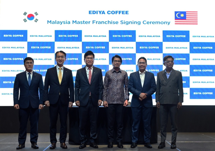 Ediya Coffee Chairman Moon Chang-ki (third from the left) poses at the master franchise agreement signing ceremony