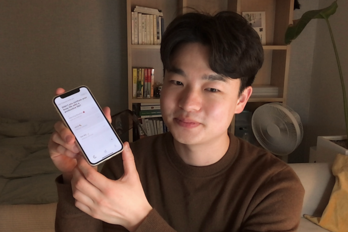 Seo　Inseok,　founder　and　CEO　of　Routinery,　holds　a　smartphone　to　show　the　Routinery　app　(Courtesy　of　Routinery)