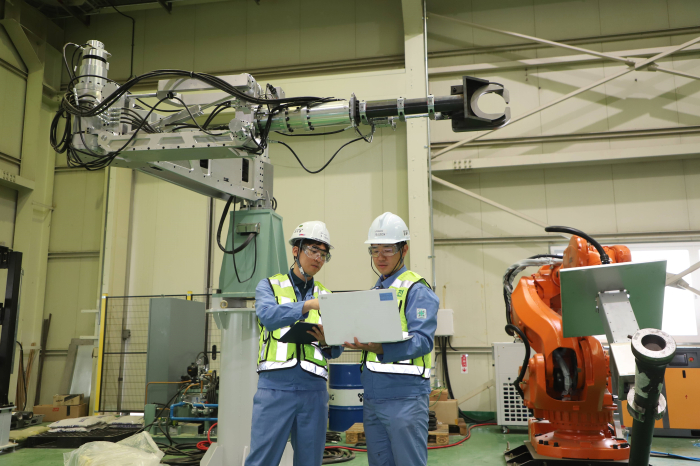 Doosan DX employees test its robotic automation system
