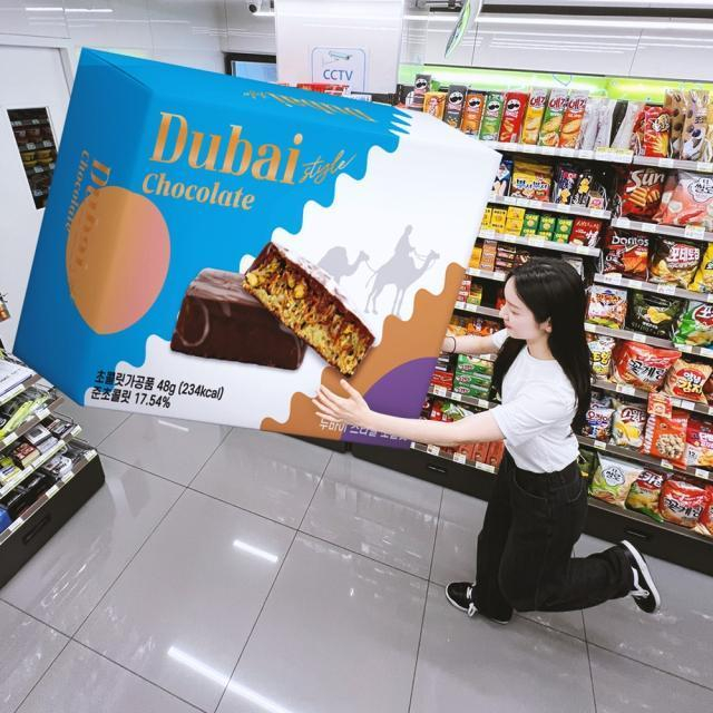 A CU employee showcases a large model box of Dubai-style chocolate, which launched on July 6. The initial stock of 200,000 units sold out on the same day (Courtesy of CU)