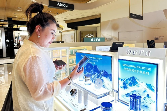 Chinese　customer　looking　at　Oera　products　at　Shilla　I　Park　Duty　Free　(Courtesy　of　Oera)