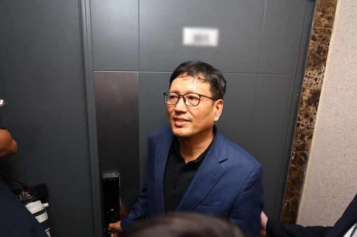 Ku Young Bae, Qoo10 founder and chief executive, enters his home in Seoul with the South Korean prosecution officials to cooperate with their search and seizure on Aug. 1, 2024 (Courtesy of Yonhap)