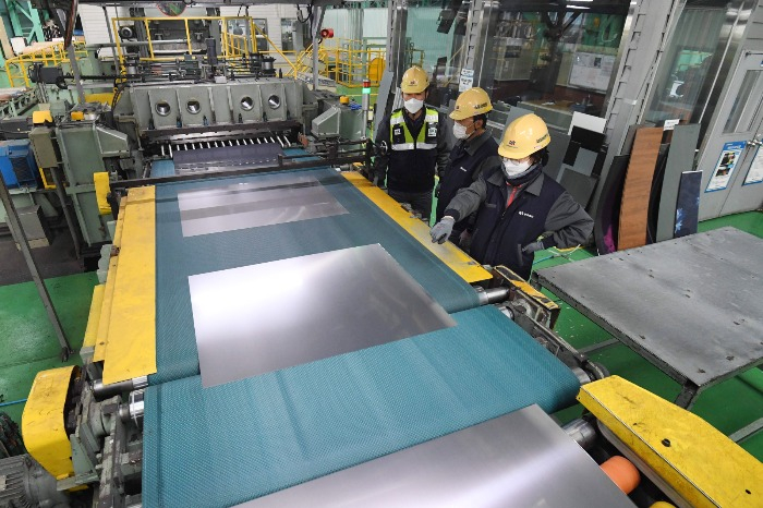 Dongkuk CM's employees inspect color coated steel sheets at the company's steek mill in Busan, South Korea