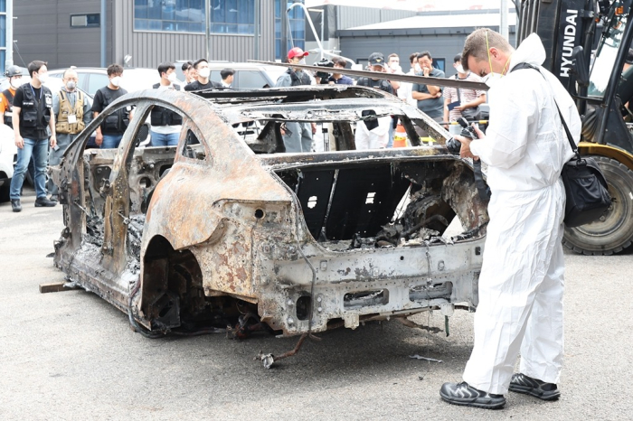 A　Mercedes-Benz　official　takes　pictures　of　an　EV　that　caught　fire　in　Incheon,　South　Korea,　during　an　investigation　on　Aug.　8,　2024　(File　photo　by　News1)