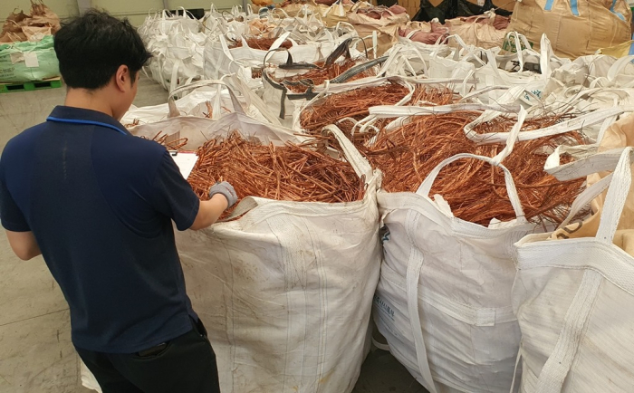 A Busan Regional Customs official inspects seized copper scrap from traders at a port in Busan (Courtesy of the Busan Regional Customs)