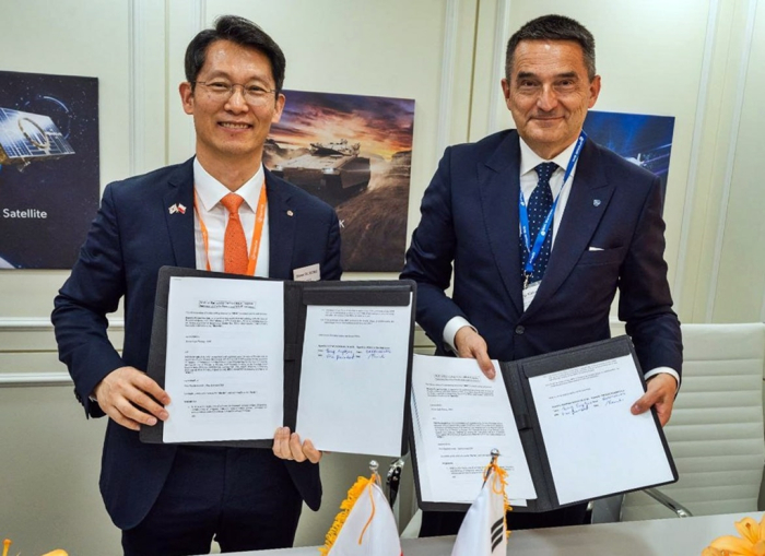 Hanwha　Ocean　Vice　President　Jung　Seung-kyun　(left)　and　Adam　Bartosiewicz,　vice　president　of　WB　Group,　pose　for　a　photo　after　signing　an　MOU　on　a　submarine　MRO　project　in　Kielce,　Poland