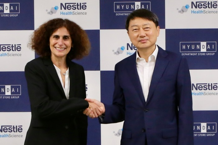 Nestle　Health　CEO　Anna　Mohl　(at　left)　shakes　hands　with　Hyundai　GF　Holdings　CEO　Jang　Hojin 