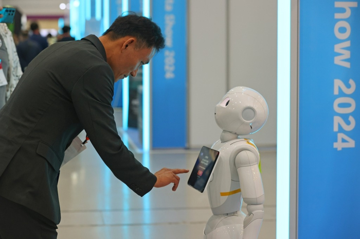 A　humanoid　robot　provides　information　to　a　visitor　at　a　technology　event　in　Seoul　on　June　19,　2024　(File　photo　by　Yonhap)
