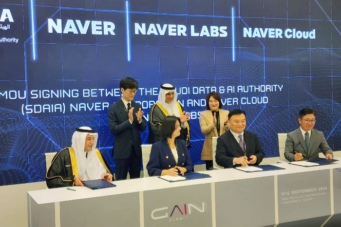 Esam　Alwagait　(far　left),　director　of　Saudi　Arabia's　National　Information　Centre　and　Naver　CEO　Choi　Soo-yeon　(seated,　second　from　left)　sign　an　MOU　for　AI　business　cooperation　on　Sept.　10,　2024　in　Riyadh