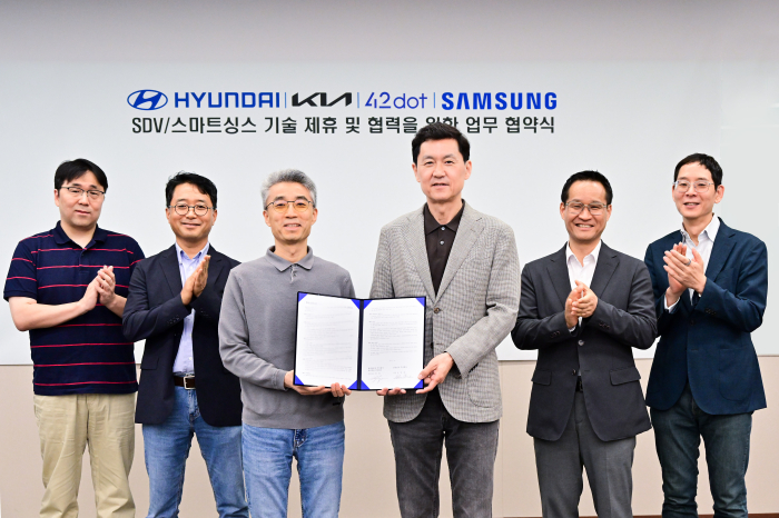 Executives from Hyundai Motor Group and Samsung Electronics pose for a photo after agreeing to partner on SDV-Galaxy smartphone connectivity services