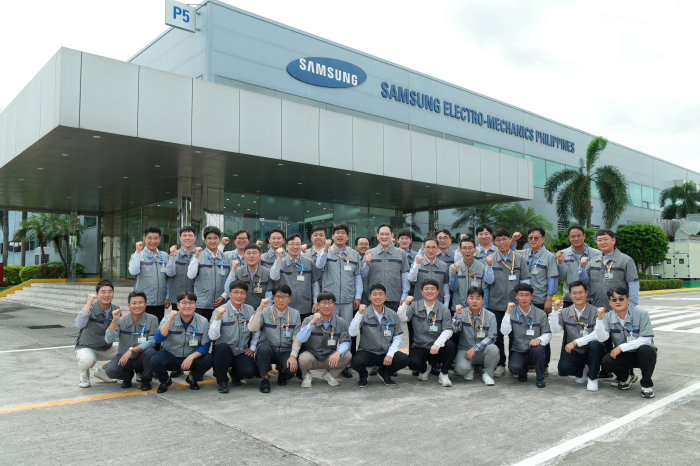 Samsung's Jay Y. Lee poses with employees at Samsung Electro-Mechanics' plant in Calamba, the Philippines