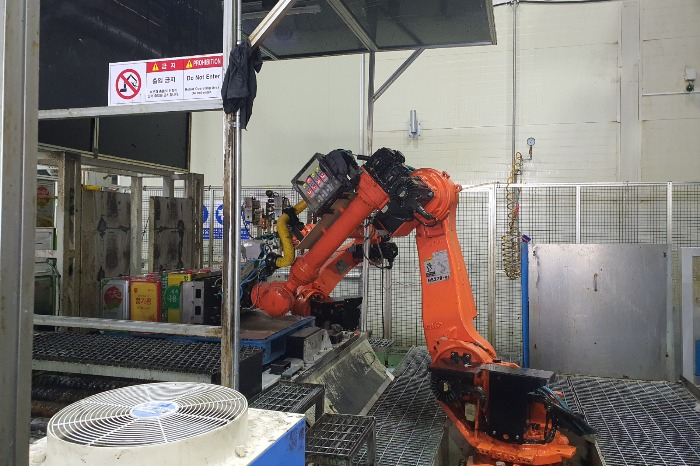 A　robot　arm　moves　used　cans　of　cooking　oil