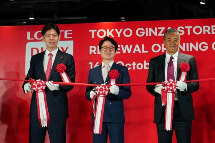 Shin Yoo-yeol, executive director of the Future Growth Office at Lotte Corporation (from left), Lotte Duty Free CEO Kim Ju-nam and Lotte Holdings CEO Genichi Tamatsuka hold a ribbon-cutting at the renewal opening ceremony on October 16