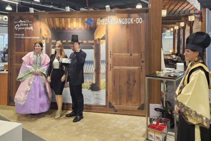 Foreign buyers try on traditional Korean dress at an exhibition booth at 2024 Korea Business Expo Vienna