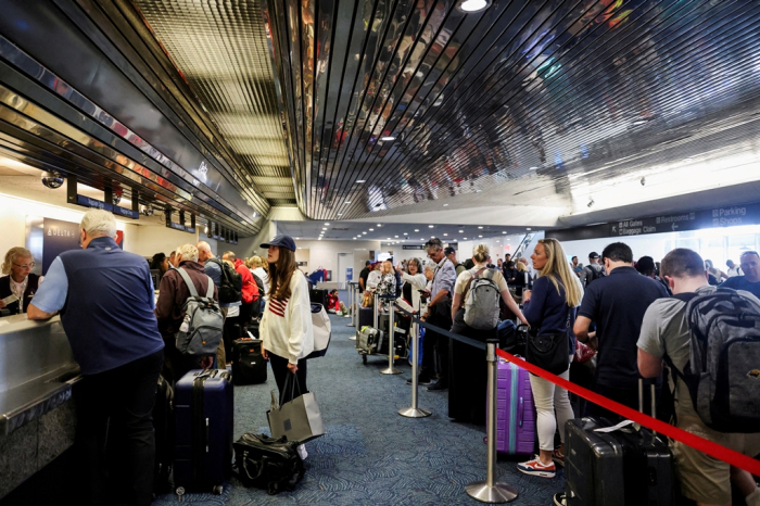 Passengers wait at Milwaukee Mitchell International Airport, on July 19, 2024, after airlines grounded flights due to a worldwide tech outage caused by an update to CrowdStrike's \