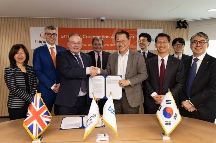 Hanwha　Ocean　CEO　Kim　Hee-cheul　(third　from　left)　poses　with　Babcock　International　CEO　David　Lockwood　(fourth　from　left) 