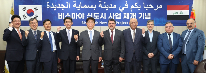 Korean　Transport　Minister　Park　Sang-woo　(fifth　from　left)　and　Iraqi　NIC　chief　Haider　Muhammed　Makkiya　(sixth　from　left)　pose　for　a　photo　after　agreeing　to　resume　Hanwha's　Bismayah　project