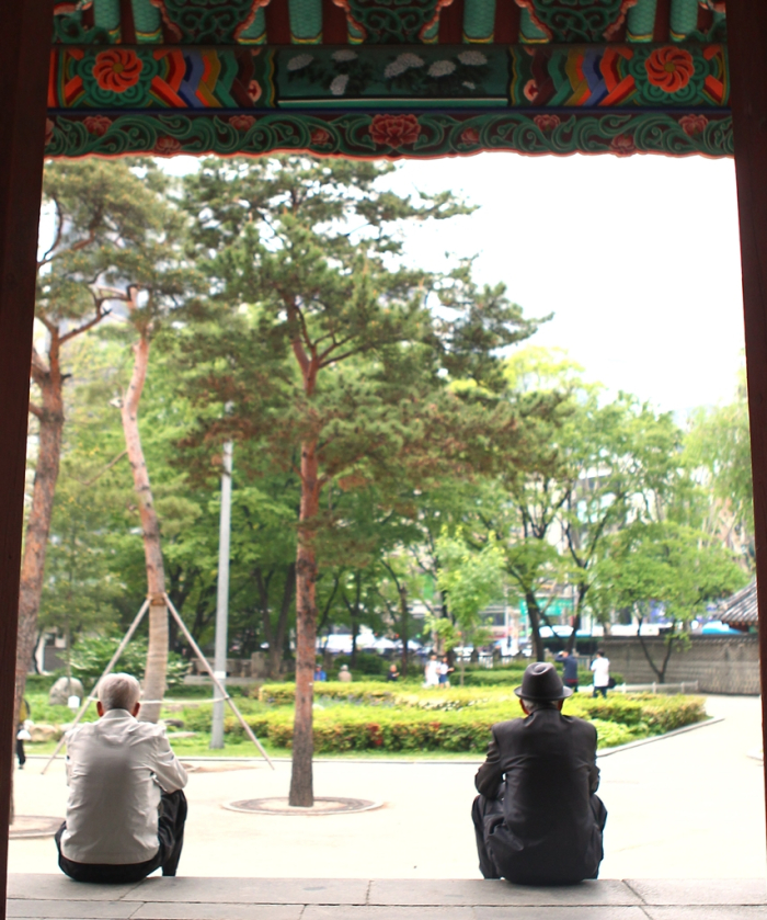 Two senior citizens sit in Tapgol Park, a hot gathering spot for elderly men in Seoul (Courtesy of Yonhap)