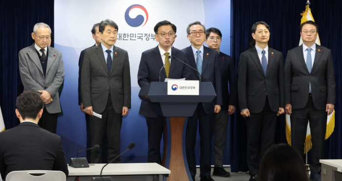 Finance Minister Choi Sang-mok (at the podium), flanked by other ministers, urges the Parliament not to impeach Acting President Hank Duck-soo early on Dec. 27, 2024