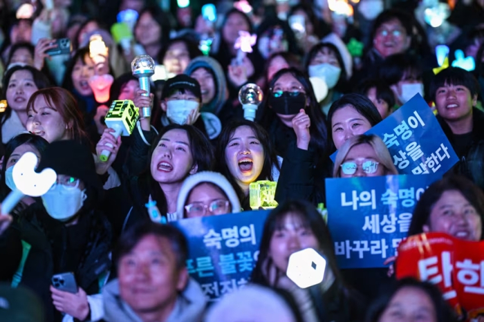 Protesters calling for the removal of President Yoon Suk Yeol celebrate news of his impeachment in Seoul (Courtesy of AFP, Getty Images)