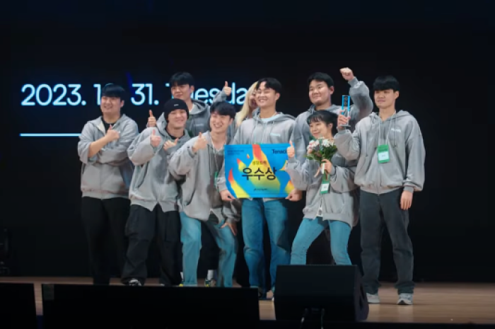 Planfit CEO Baek Hyeonwoo (center), surrounded by his colleagues, holds an award won at a demo day (Courtesy of Planfit)