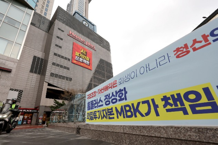 A　banner　demanding　that　MBK　take　responsibility　for　the　Homeplus　fallout　(Courtesy　of　Yonhap)