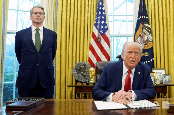 US　Treasury　Secretary　Scott　Bessent　(left)　stands　beside　President　Trump　as　he　signs　off　on　an　administrative　order　at　the　Whtite　House　on　Feb.　3,　2025　(Courtesy　of　AP　via　Newsis)