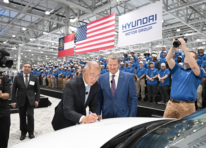 Georgia Gov. Brian Kemp looks on as Hyundai Motor Chairman Chung Euisun signs an IONIQ 5 during the opening ceremony of Hyundai Motor Group Metaplant America (HMGMA) in Ellabell, Georgia, on March 26, 2025