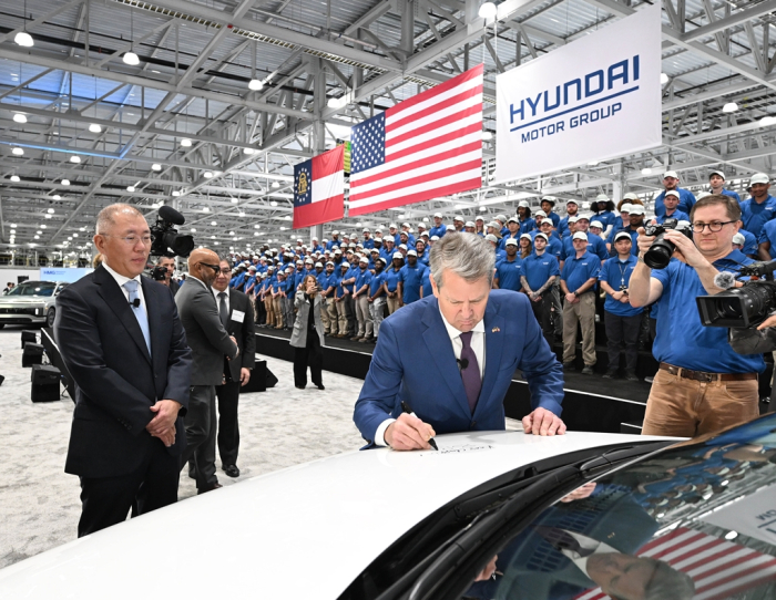 Hyundai Motor Chairman Chung Euisun (left) looks on as Georgia Gov. Brian Kemp signs an IONIQ 5 during the opening ceremony of Hyundai Motor Group Metaplant America (HMGMA) in Ellabell, Georgia, on March 26, 2025
