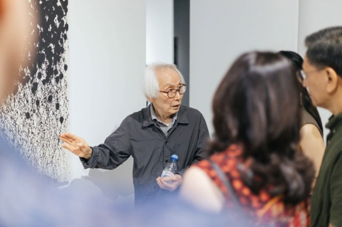 Artist Choi Sang Chul explains his painting to gallery visitors at Baik Art Jakarta (Courtesy of Baik Art)