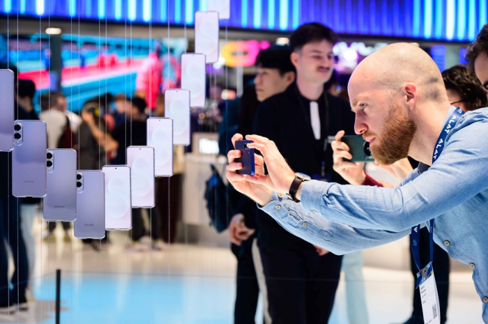 Visitors to Mobile World Congress (MWC) 2025 in Barcelona, Spain, take photos of the Galaxy S25 Edge smartphones on display at the Samsung booth in March 2025