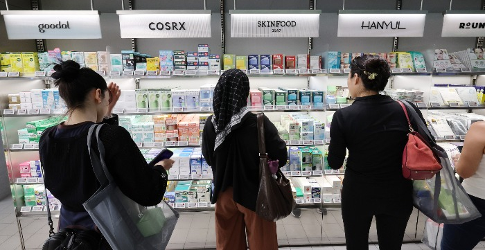 Tourists browse for Korean cosmetics at an Olive Young store in Seoul (Courtesy of News1 Korea)