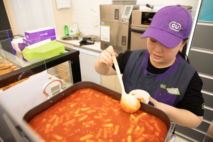 A CU employee at CU's first Kazakhstan convenience store outlet in Almaty makes tteokbokki inside the store