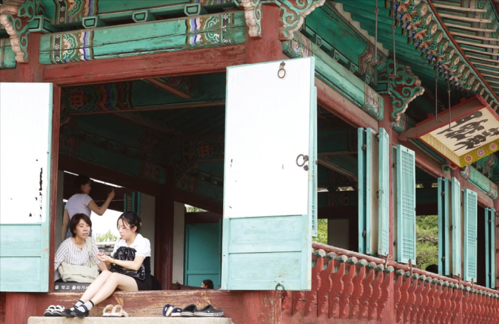 Chinese tourists visiting Hwahongmun Gate in Hwaseong Fortress, Suwon, Gyeonggi Province, sit on the floor of the building