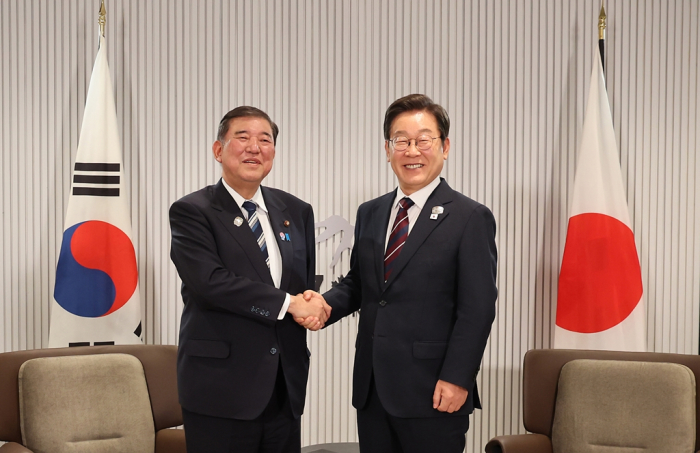 President Lee Jae Myung (right) shakes hands with Japanese Prime Minister Shigeru Ishiba during their talks on the sidelines of the G7 Summit in Kananaskis, Alberta, on June 17, 2025