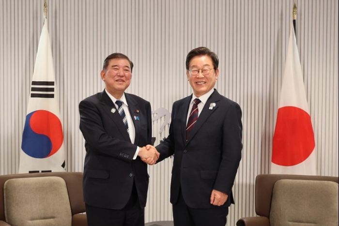 President Lee Jae Myung (right) shakes hands with Japanese Prime Minister Shigeru Ishiba during their talks on the sidelines of the G7 Summit in Kananaskis, Alberta, on June 17, 2025