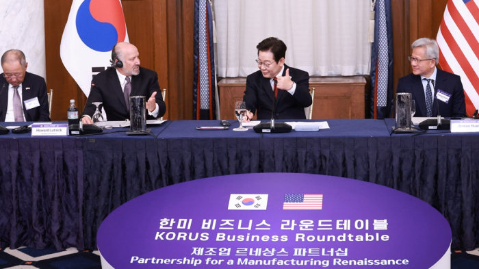 Sided by US Commerce Secretary Howard Lutnick (left) and Nvidia CEO Jensen Huang (right), Korean President Lee Jae Myung presides over the Korea-US business roundtable