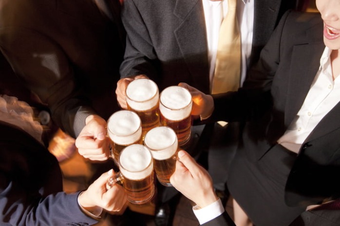 Korean office workers raising soju glasses during a hoesik after-work dinner gathering